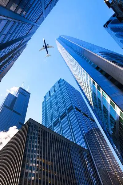 Looking skyward with Chicago skyscrapers on all sides, a jet airliner passing overhead