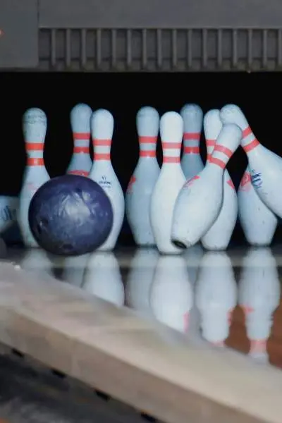 Bowling balls crash into pins at a bowling alley