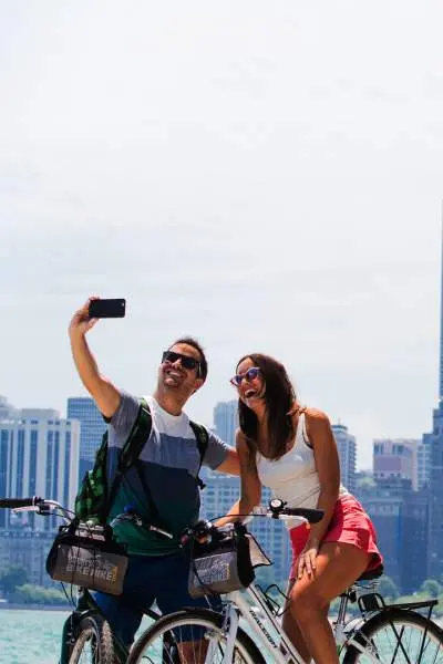 A couple riding bikes and taking a photo along the Chicago lakefront